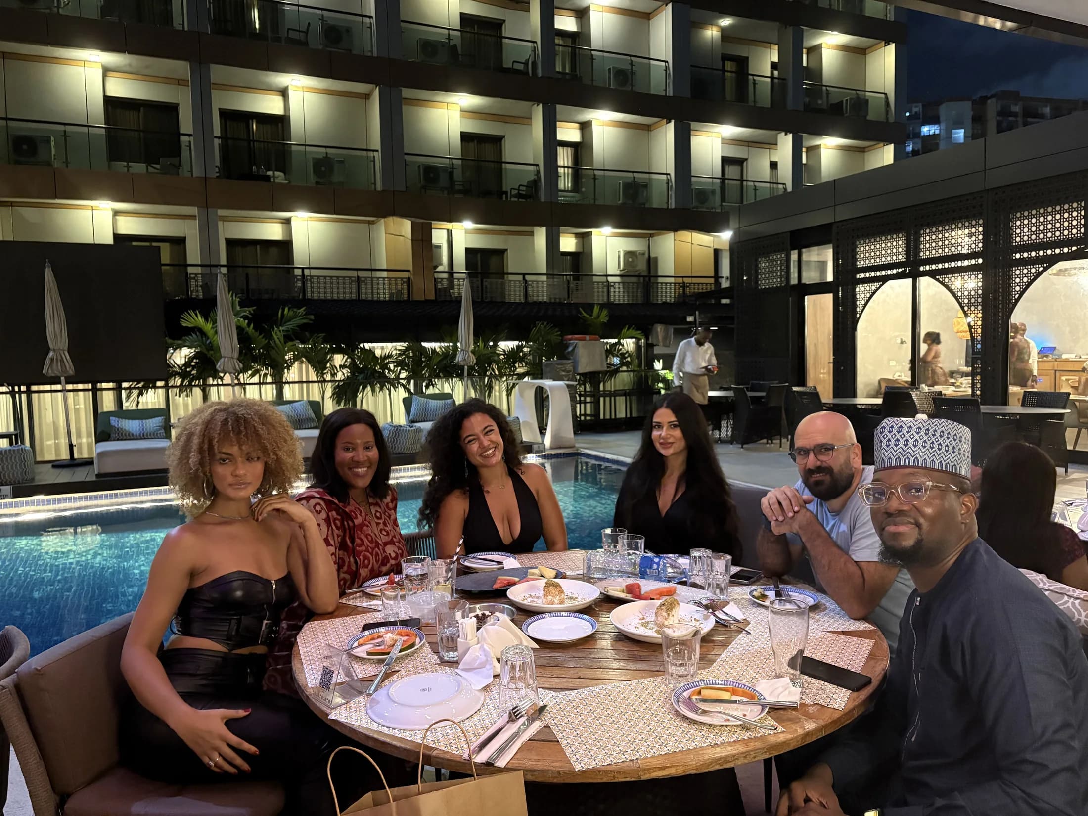 Members gathered around a poolside dinner table